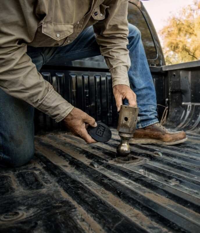 b&w hitch being placed inside bed of work truck for storage