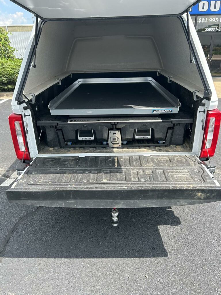 Work truck with hard shell on top along with pull out storage drawers behind the tailgate and a large flat pullout surface for easy access to items in bed