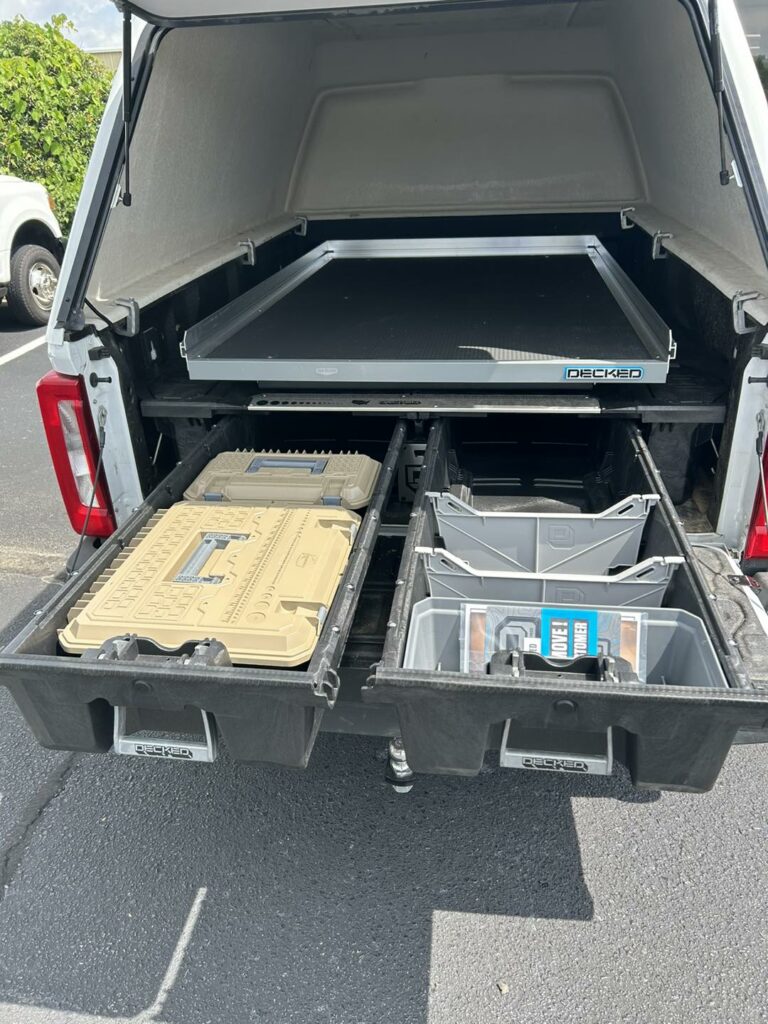 Work truck with storage drawers installed underneath bed that has a hard shell